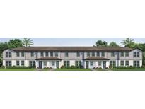 Charming townhome showcases a welcoming entrance with a lush, green lawn at 753 Mystic Gardens Dr, Apopka, FL 32703