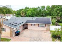 Charming single-story home featuring solar panels, brick accents, and a spacious brick driveway at 774 Hendrix Ave, Orlando, FL 32825