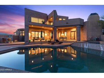 Luxury home with a stunning pool and desert landscape at sunset at 14021 E Milton Ct, Scottsdale, AZ 85262