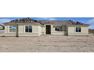 Under-construction single-story stucco home featuring a Spanish tile roof, and white-framed windows at 1928 W Big Sky Ln, Queen Creek, AZ 85144
