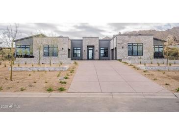 A modern desert home with a long driveway and stone accents at 12297 E Troon Vista Dr # 255, Scottsdale, AZ 85255