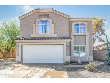 Two-story home featuring a two-car garage, desert landscaping and tile roof at 9143 W Harmony Ln, Peoria, AZ 85382