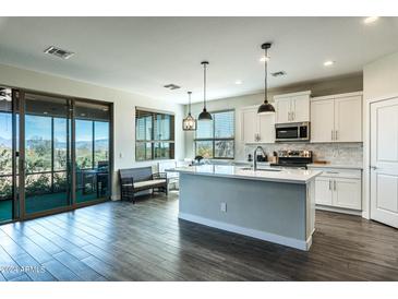 Modern kitchen with white cabinets, stainless steel appliances, and an island at 16302 E Bobwhite Way, Scottsdale, AZ 85262