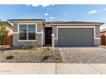 Charming single-story home featuring stone accents, a gray garage door, and a well-manicured front yard at 18507 E Camila Dr, Gold Canyon, AZ 85118