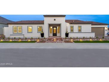Charming single-story home with a clay tile roof, lighted brick path, and manicured landscaping at 17448 W Carlisle Dr, Surprise, AZ 85388