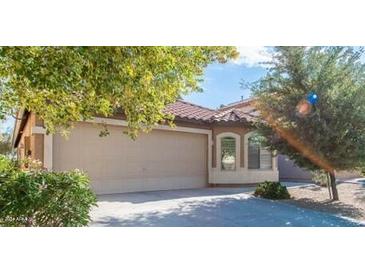 Beige house with a two-car garage and landscaping at 21129 N Grantham Rd, Maricopa, AZ 85138