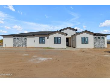 Single story home featuring stone accents, black trim, and a low maintenance landscape at 26615 S 181St Pl, Queen Creek, AZ 85142