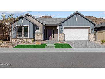 Charming single-Gathering home featuring stylish gray siding, stone accents, and a well-manicured front yard at 32480 N 134Th Ln, Peoria, AZ 85383