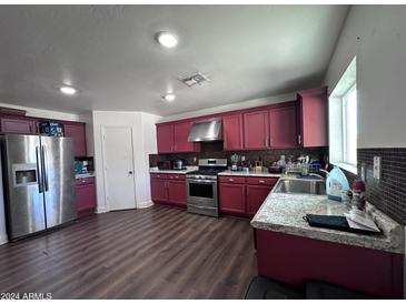 Bright kitchen with stainless steel appliances and dark wood cabinets at 6245 W Southgate St, Phoenix, AZ 85043