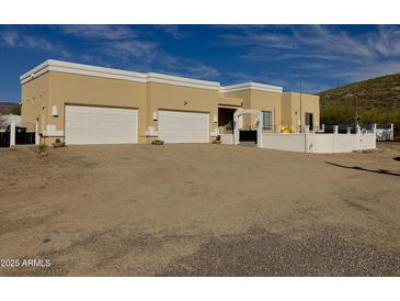 Inviting single-story home featuring a neutral stucco exterior, a three-car garage and a well-kept front yard at 44421 N 20Th St, New River, AZ 85087