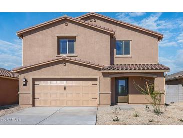 Inviting two-story home featuring a two-car garage, desert landscaping, and a stylish, covered front entry at 6486 S 246Th Ln, Buckeye, AZ 85326