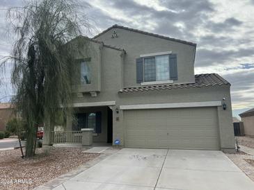 Two-story home featuring a neutral color scheme, two-car garage, and well-maintained front yard at 23671 W Wayland Dr, Buckeye, AZ 85326