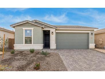 One-story house with green exterior, two-car garage, and landscaped front yard at 40115 W Elm Dr, Maricopa, AZ 85138