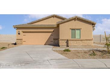 Tan single-story home featuring a two-car garage and neutral desert landscaping at 680 W Crowned Dove Trl, Casa Grande, AZ 85122