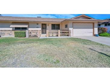 Charming single-story home features a front yard with a walkway and attached garage at 10802 W Cameo Dr, Sun City, AZ 85351