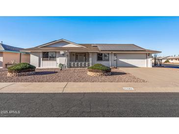 Single story home with solar panels and landscaped yard at 11104 W Gaytime Ct, Sun City, AZ 85351