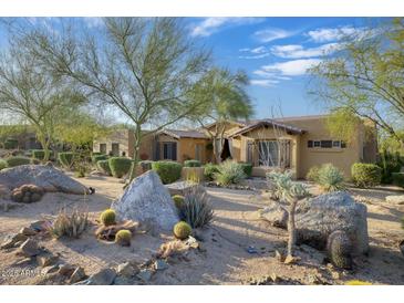 Charming home with desert landscaping featuring rocks, cacti, and mature trees at 8167 E Sand Flower Dr, Scottsdale, AZ 85266