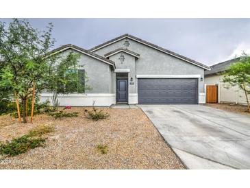 Charming single-story home featuring a two-car garage, desert landscaping, and modern architectural details at 1157 W Paradise Way, Casa Grande, AZ 85122