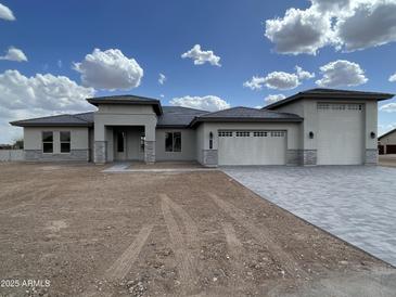 Charming single-story home featuring a neutral stucco finish, gray stone accents, and a spacious three-car garage at 1101 E Dolores Rd, Phoenix, AZ 85086