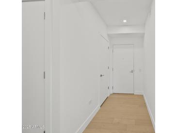 Bright hallway with wood floors and white walls with doors at 7127 E Rancho Vista Dr # 4012, Scottsdale, AZ 85251
