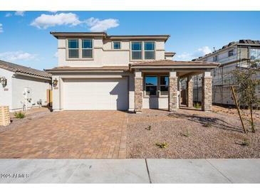 Charming two-story home features a brick driveway and covered porch with stone pillars at 17632 W Oregon Ave, Litchfield Park, AZ 85340