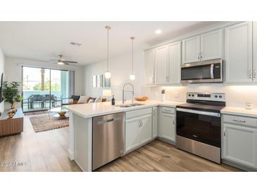 Bright kitchen features stainless steel appliances, pendant lighting, and a convenient breakfast bar at 2511 W Queen Creek Rd # 179, Chandler, AZ 85248