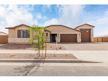 Charming single-story home featuring desert landscaping, three car garage and a neutral color palette at 19655 E Estrella Rd, Queen Creek, AZ 85142