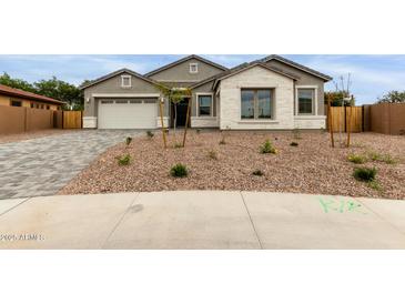 Charming single-story home featuring a two-car garage and desert landscaping in front at 21921 S 197Th St, Queen Creek, AZ 85142