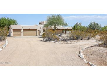 Front view of a stucco home with a two-car garage and desert landscaping at 19927 W Meadowbrook Ave, Litchfield Park, AZ 85340