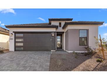 Charming single-Gathering home showcases a modern design and appealing curb appeal with a gray brick driveway at 4353 N 203Rd Ave, Buckeye, AZ 85396