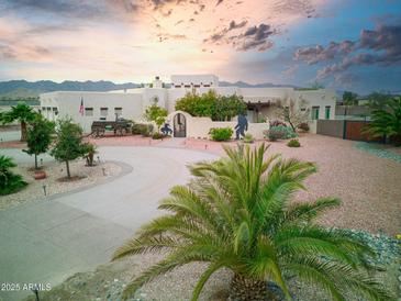 Stunning single Gathering home showcasing a circular driveway, charming desert landscaping, and unique architectural details at 19950 W Cambridge Ave, Buckeye, AZ 85396