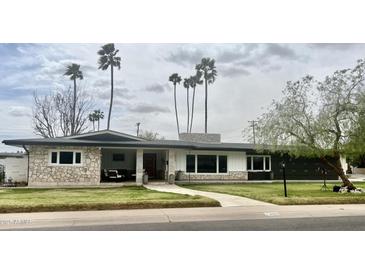 Charming single-story home with stone accents, a covered porch, and lush lawn at 895 W Tyson St, Chandler, AZ 85225