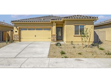 Charming single-story home featuring a two-car garage, desert landscaping, and a tile roof at 24606 W St Catherine Ave, Buckeye, AZ 85326