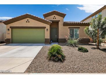 One-story home with green garage door and desert landscaping at 42459 W Paseo Dr, Maricopa, AZ 85138
