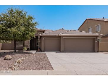 Tan three-car garage house with stone accents and a landscaped front yard at 3407 E Glacier Pl, Chandler, AZ 85249