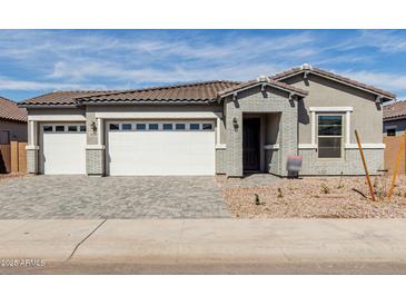 Charming single-story home with a three-car garage, brick accents, and a well-maintained front yard at 11950 W Parkway Ln, Avondale, AZ 85323