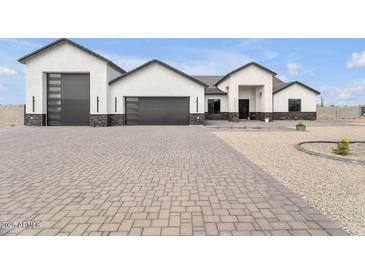 Stunning modern home with a large garage and a beautifully paved driveway and desert landscape at 32278 N 168Th Ave, Surprise, AZ 85387