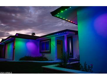 Charming home featuring colorful lights outlining the roofline against a beautiful evening sky at 2236 E Blanche Dr, Phoenix, AZ 85022