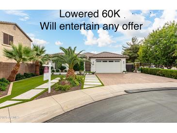 Beautiful single-story home with a landscaped front yard and three-car garage at 10803 E Ramblewood Cir, Mesa, AZ 85212