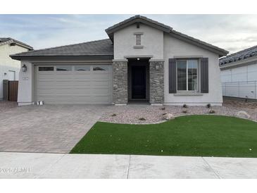 Single-story home with gray exterior, stone accents, and a landscaped front yard at 9987 W Verde Ln, Avondale, AZ 85392