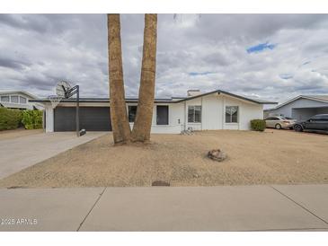 Charming single-story home featuring a well-maintained yard with desert landscaping and a two-car garage at 18009 N 15Th Dr, Phoenix, AZ 85023