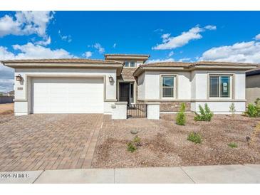 Charming single-story home featuring a brick driveway and a two-car garage at 8746 W Denton Ln, Glendale, AZ 85305