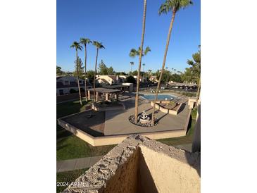 Community pool with palm trees and a relaxing patio area at 540 N May St # 3093, Mesa, AZ 85201