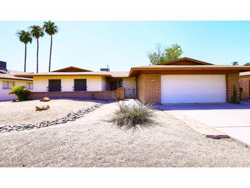 Charming single-story home with desert landscaping, brick accents, and an attached two-car garage at 1531 W Plana Ave, Mesa, AZ 85202