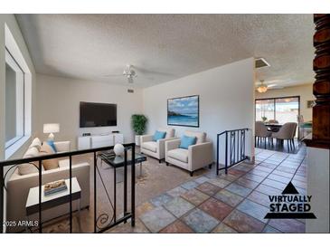 Bright living room features tiled floors, comfy seating, and views to the dining area at 2104 N Olive Ave, Mesa, AZ 85203