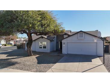 Charming single-story home with a two-car garage and mature landscaping at 9127 W Banff Ln, Peoria, AZ 85381