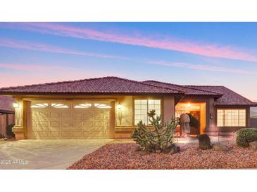 Charming single-story home featuring a tile roof, desert landscaping, and a warm, inviting entrance at 20616 N Ventana W Dr, Sun City, AZ 85373