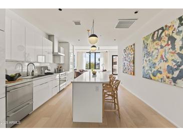 Modern white kitchen with island seating and open floor plan at 312 E Windsor Ave # 11, Phoenix, AZ 85004