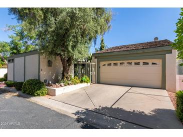 Attached home's two-car garage is front-facing and features mature landscaping on a sunny day at 8101 N Central Ave # 6, Phoenix, AZ 85020