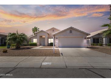 Charming single-story home featuring a well-manicured front yard and a two-car garage at 2390 S Walnut Dr, Chandler, AZ 85286